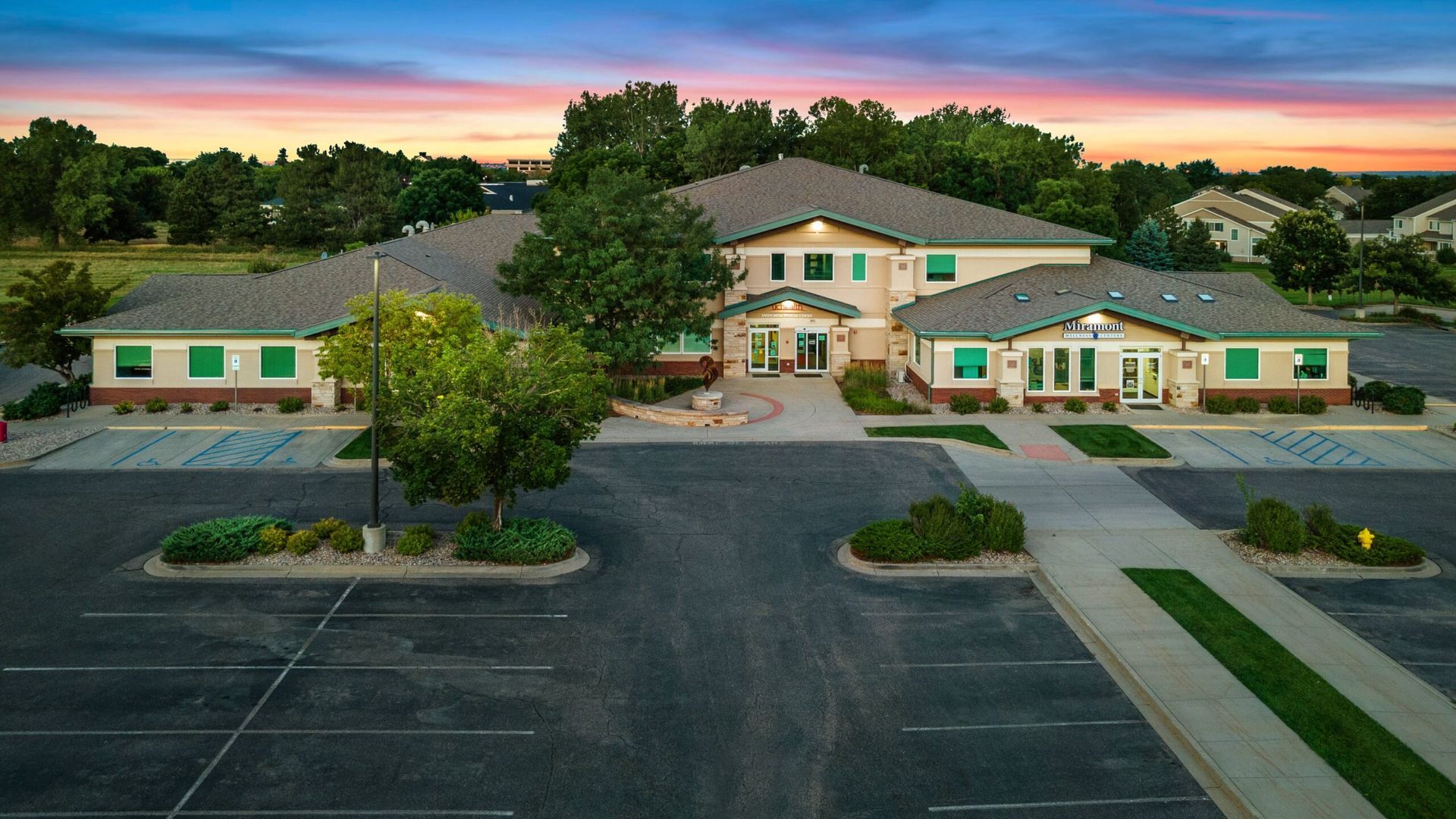 An aerial view of a large building with a parking lot in front of it.