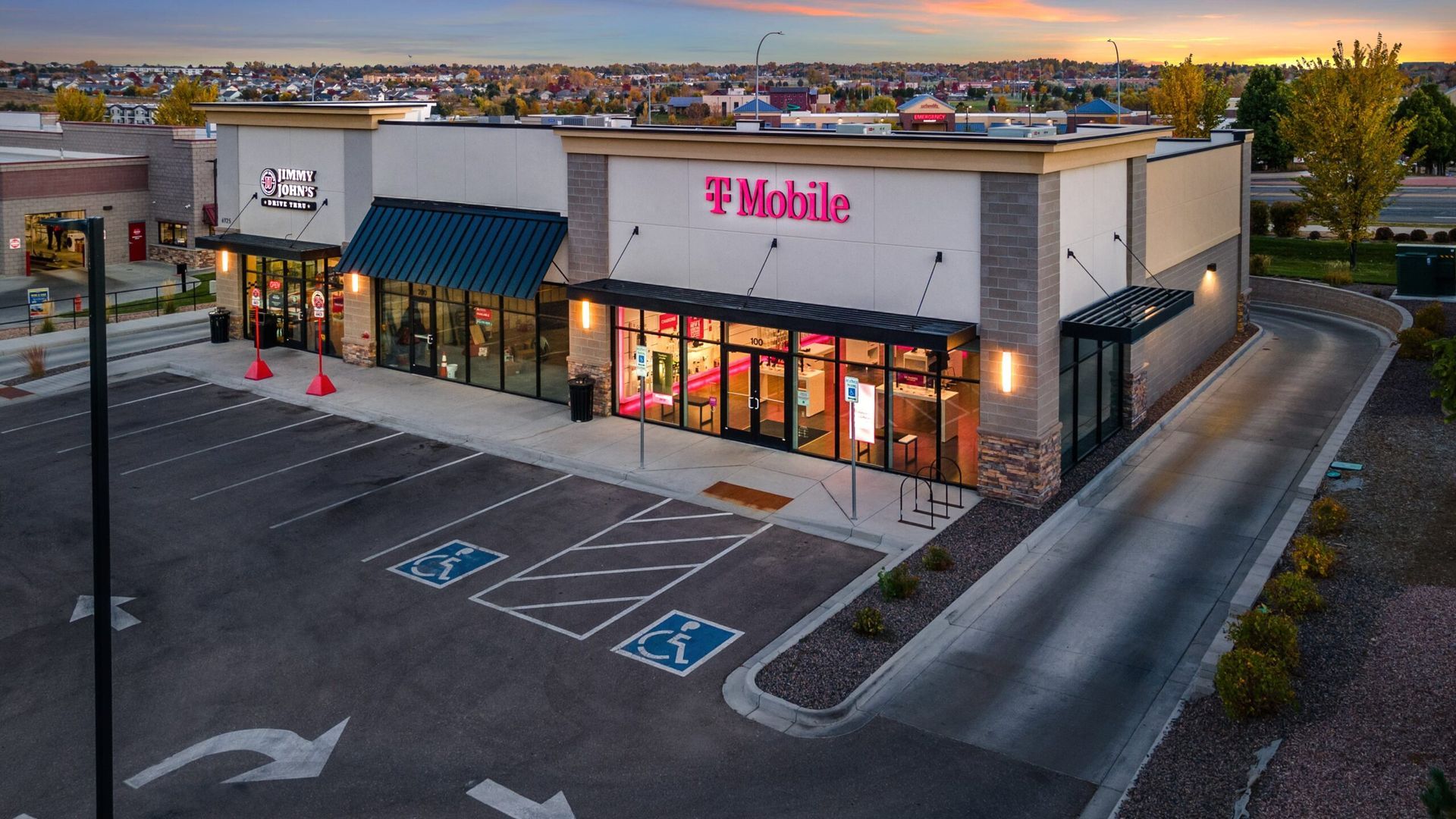 An aerial view of a t mobile store with a parking lot in front of it.