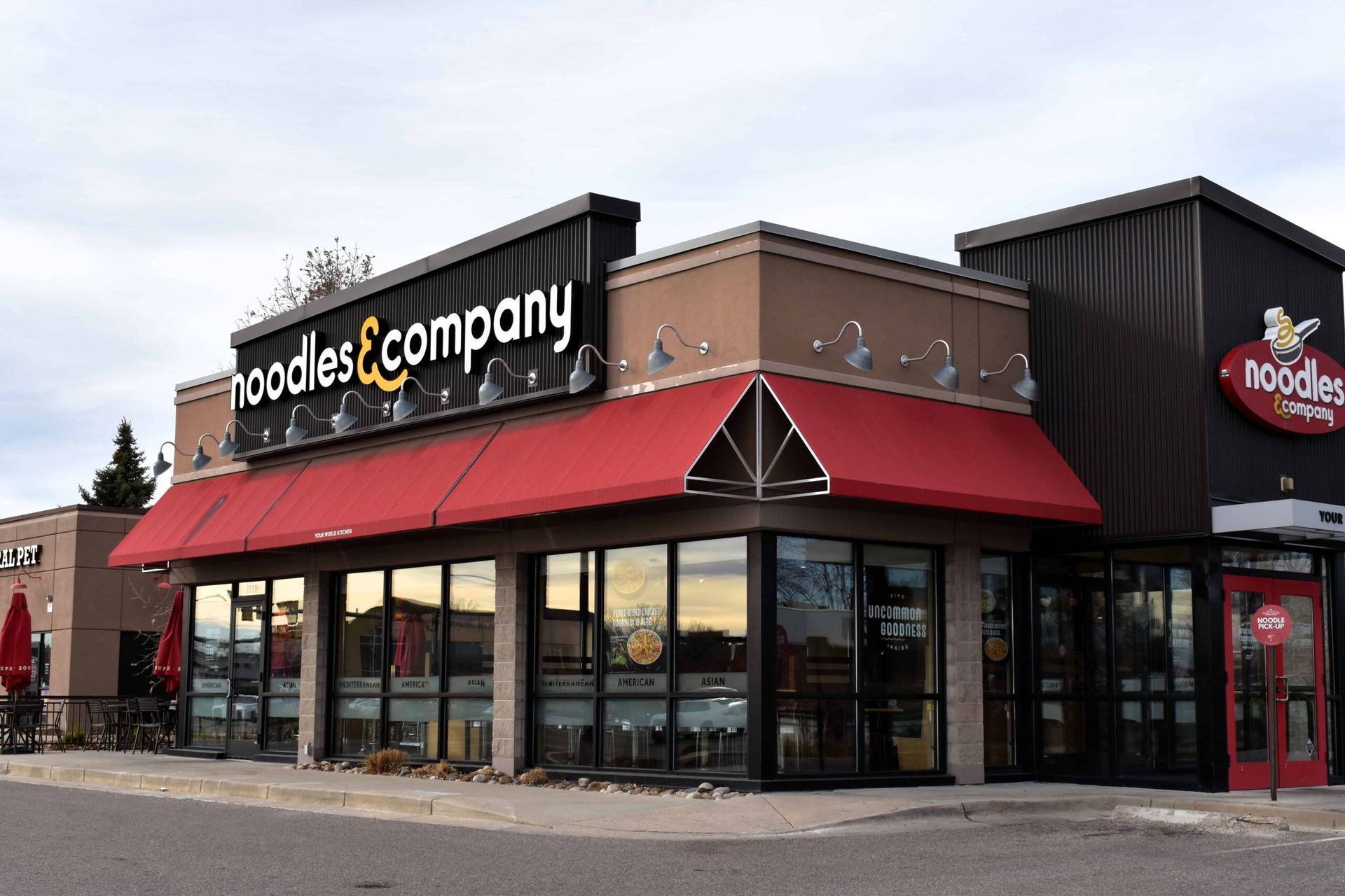 A noodles and company restaurant with a red awning