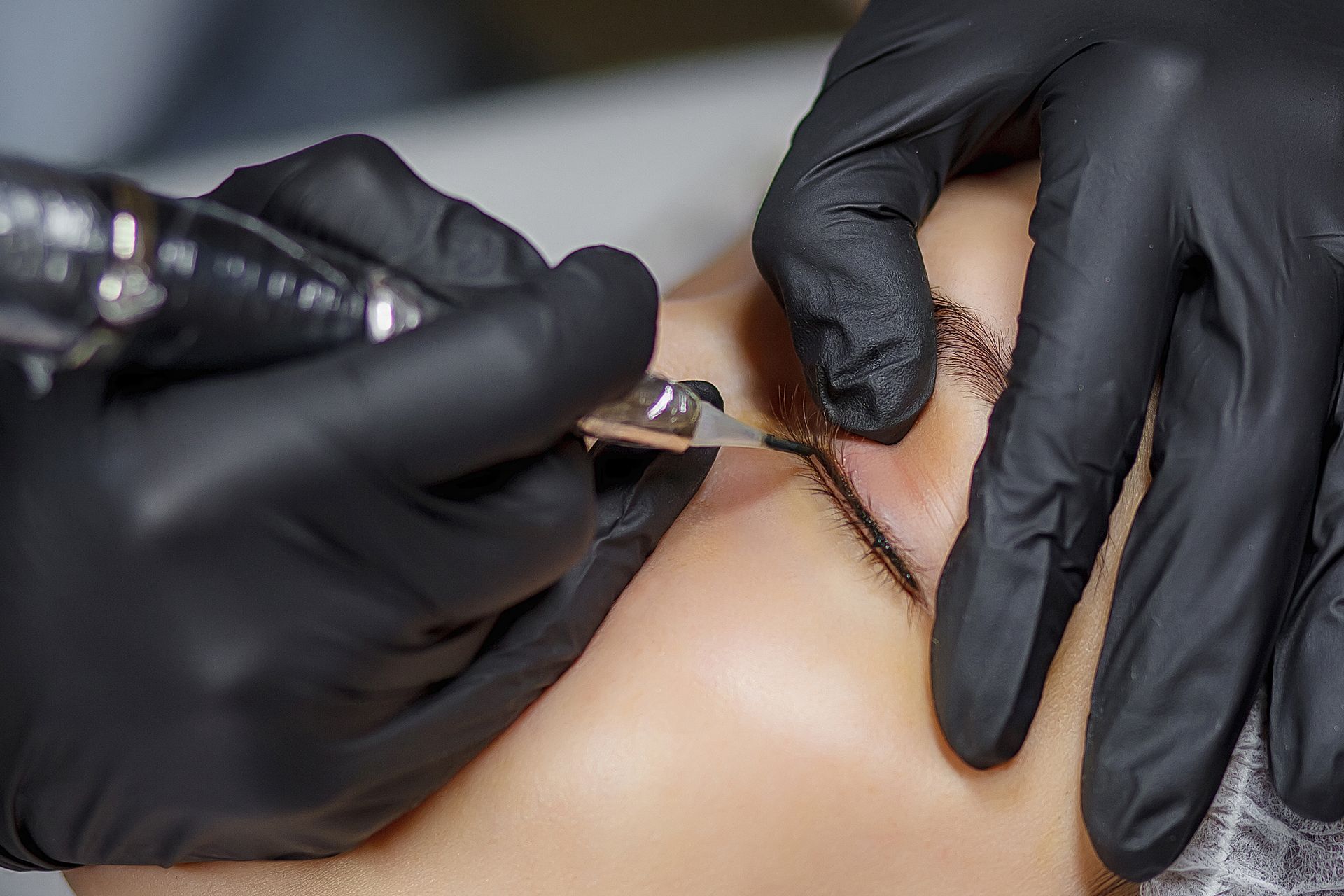 Eine Frau lässt sich ein Permanent-Make-up-Tattoo auf die Augenbrauen tätowieren.