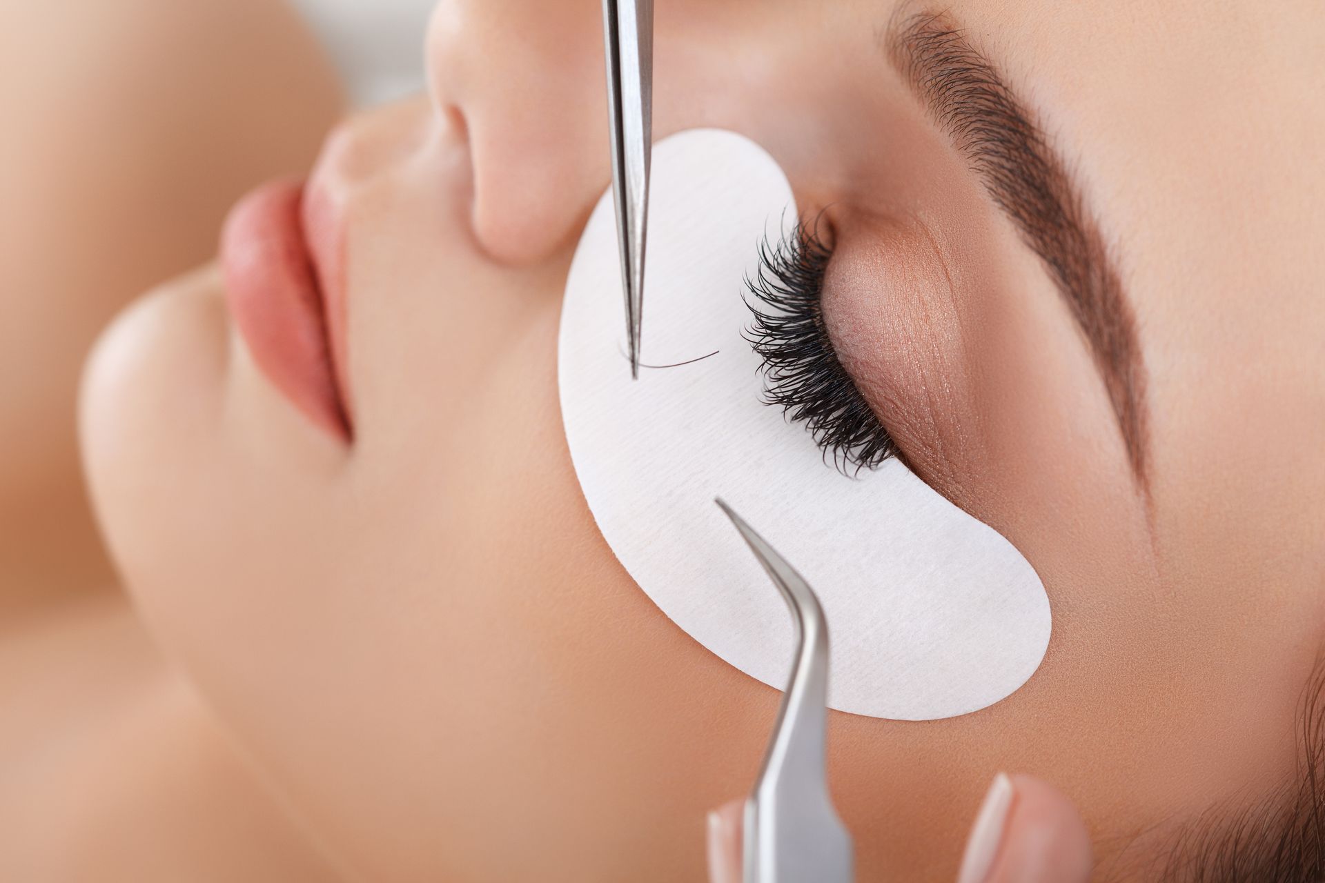 Eine Frau bekommt in einem Schönheitssalon Wimpernverlängerungen.