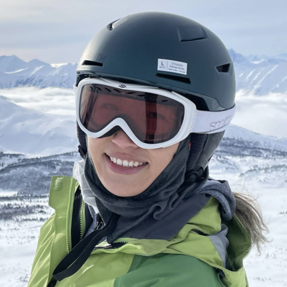 Ashley, an EVR employee, wearing a helmet sitting on an off road bike in the Rocky Mountains. 
