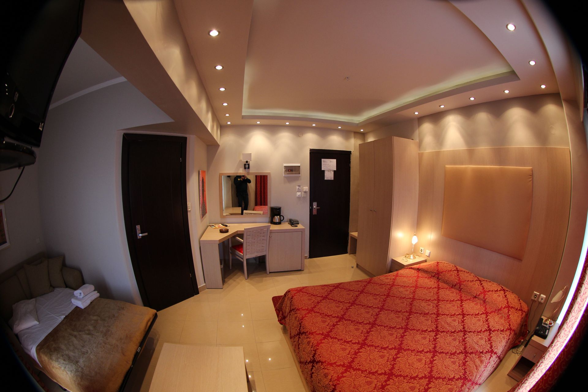 A hotel room with a large bed and a desk