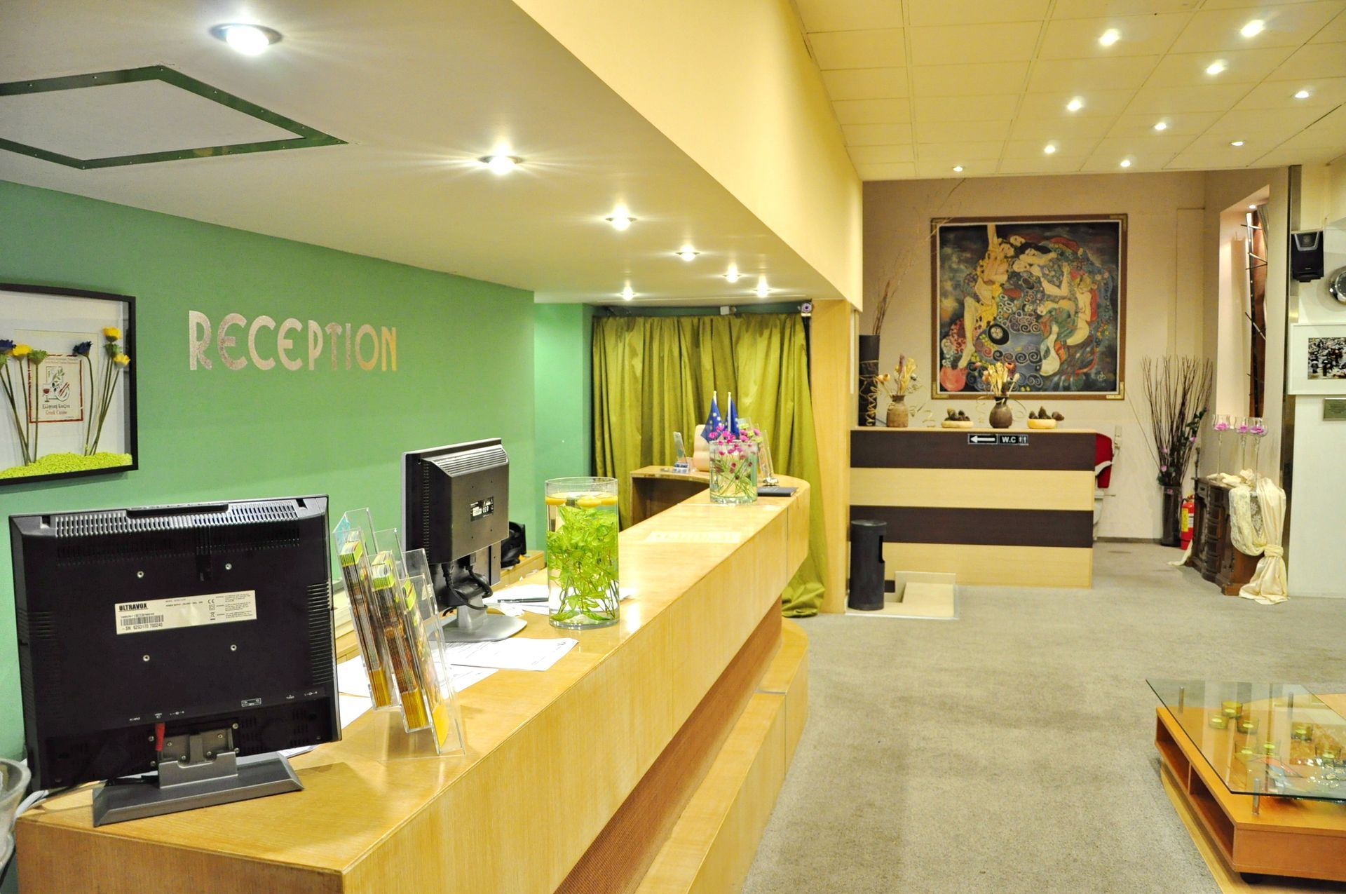 A hotel lobby with a green wall that says reception