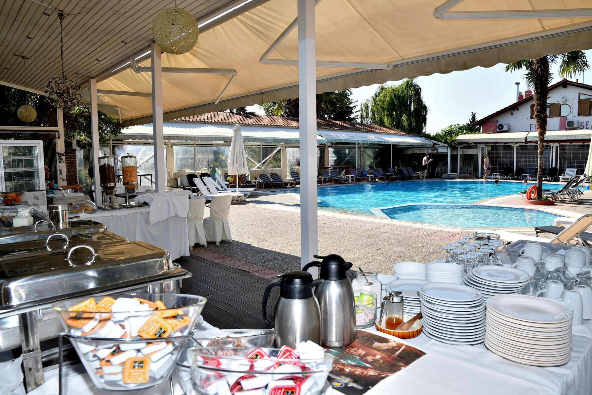 A buffet is set up in front of a swimming pool
