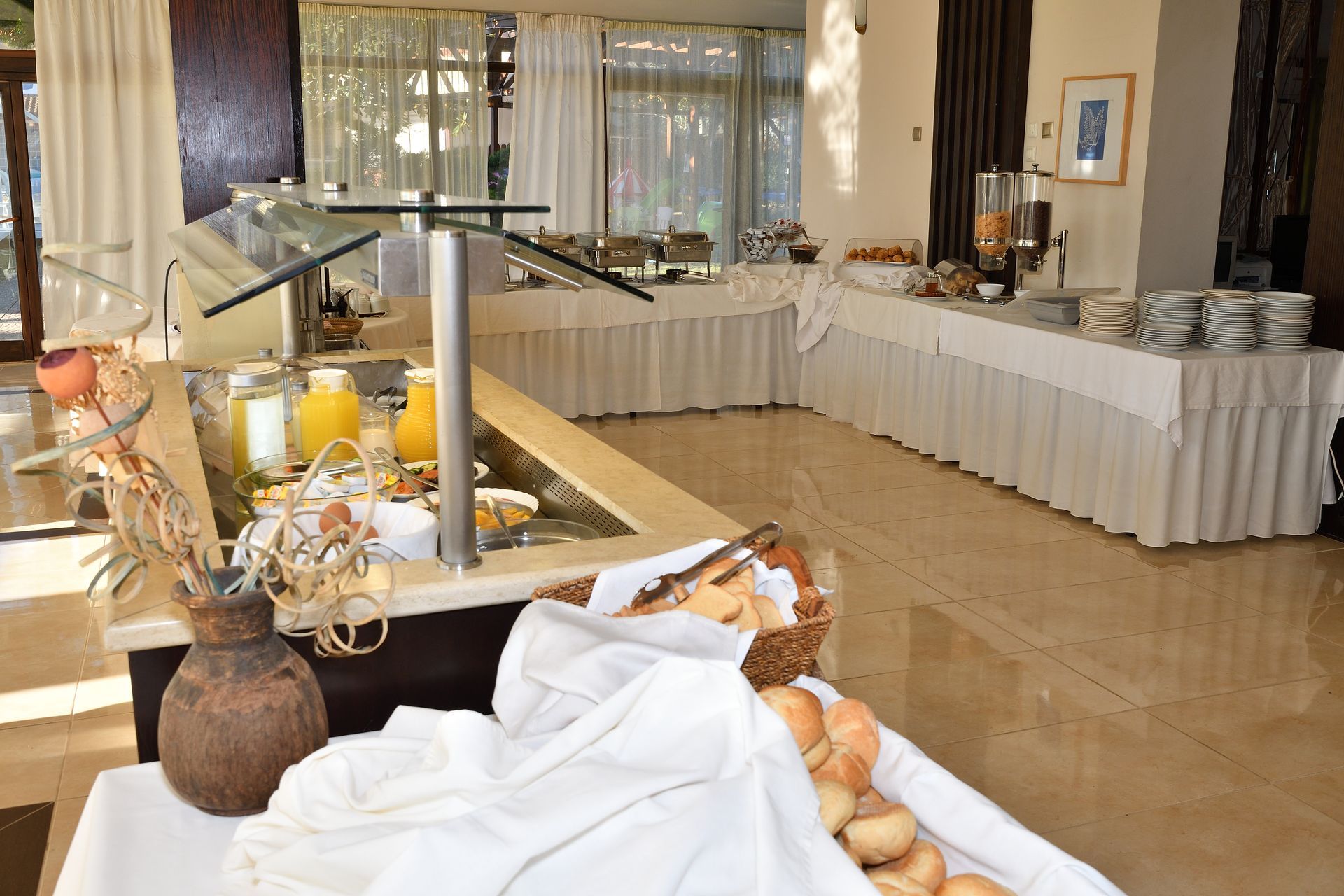 A buffet in a restaurant with a basket of bread on the table.