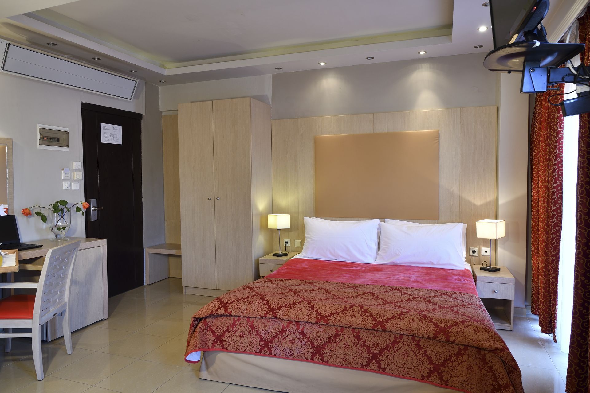 A hotel room with a large bed and a desk.