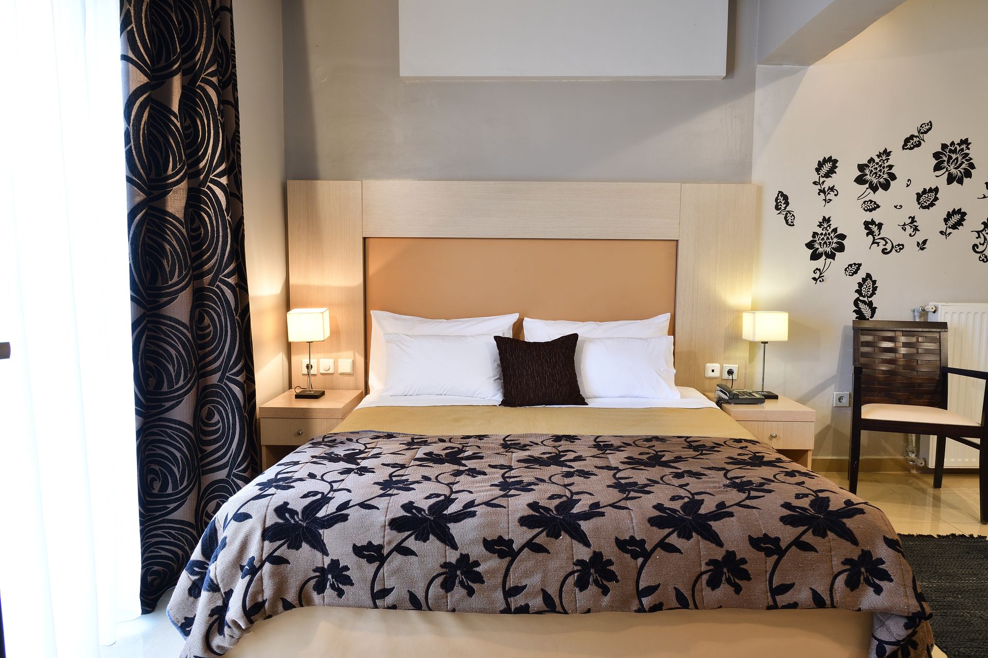 A hotel room with a large bed and a chair