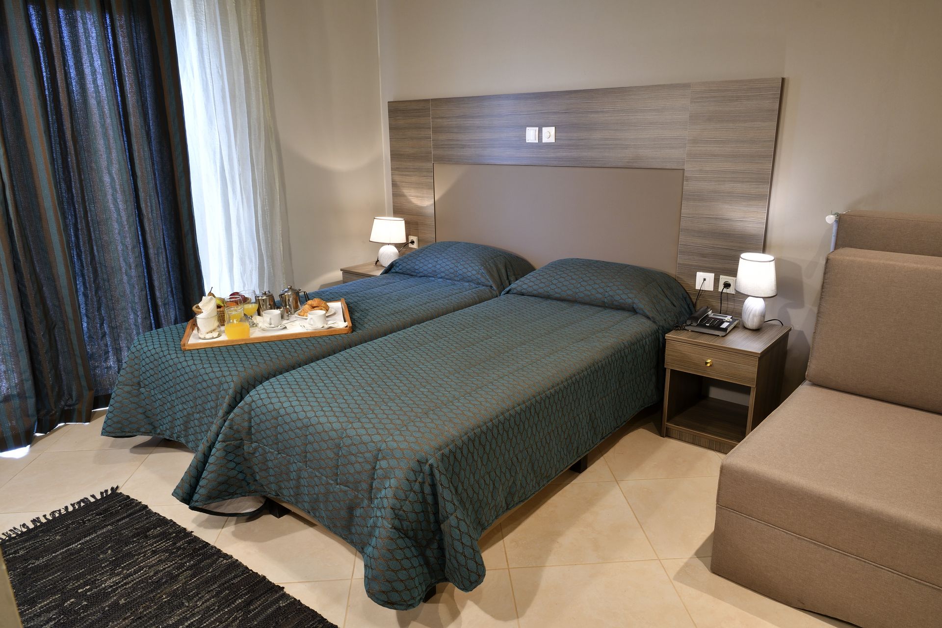 A hotel room with two beds and a tray of food on the bed
