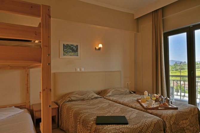 A hotel room with two beds and a bunk bed.