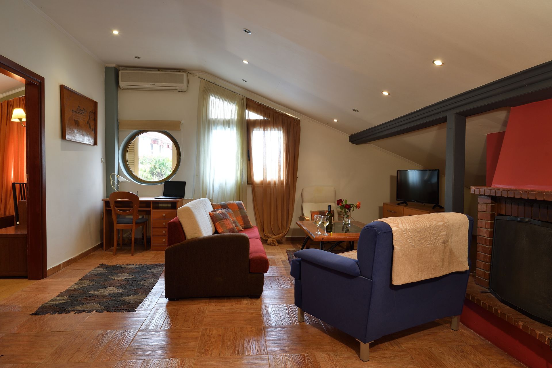 A living room with a couch , chair , table and fireplace.
