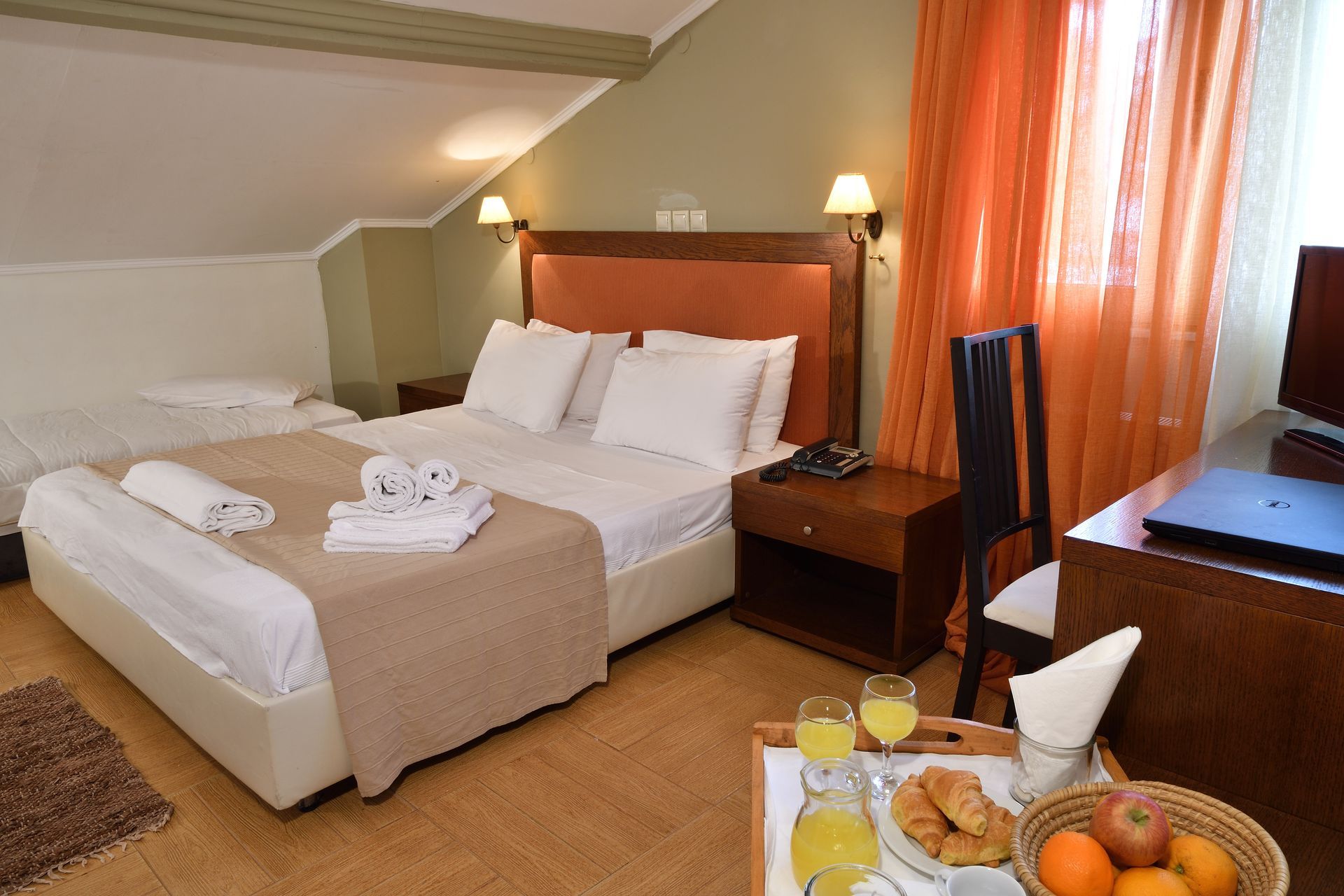 A hotel room with a large bed and a tray of food.