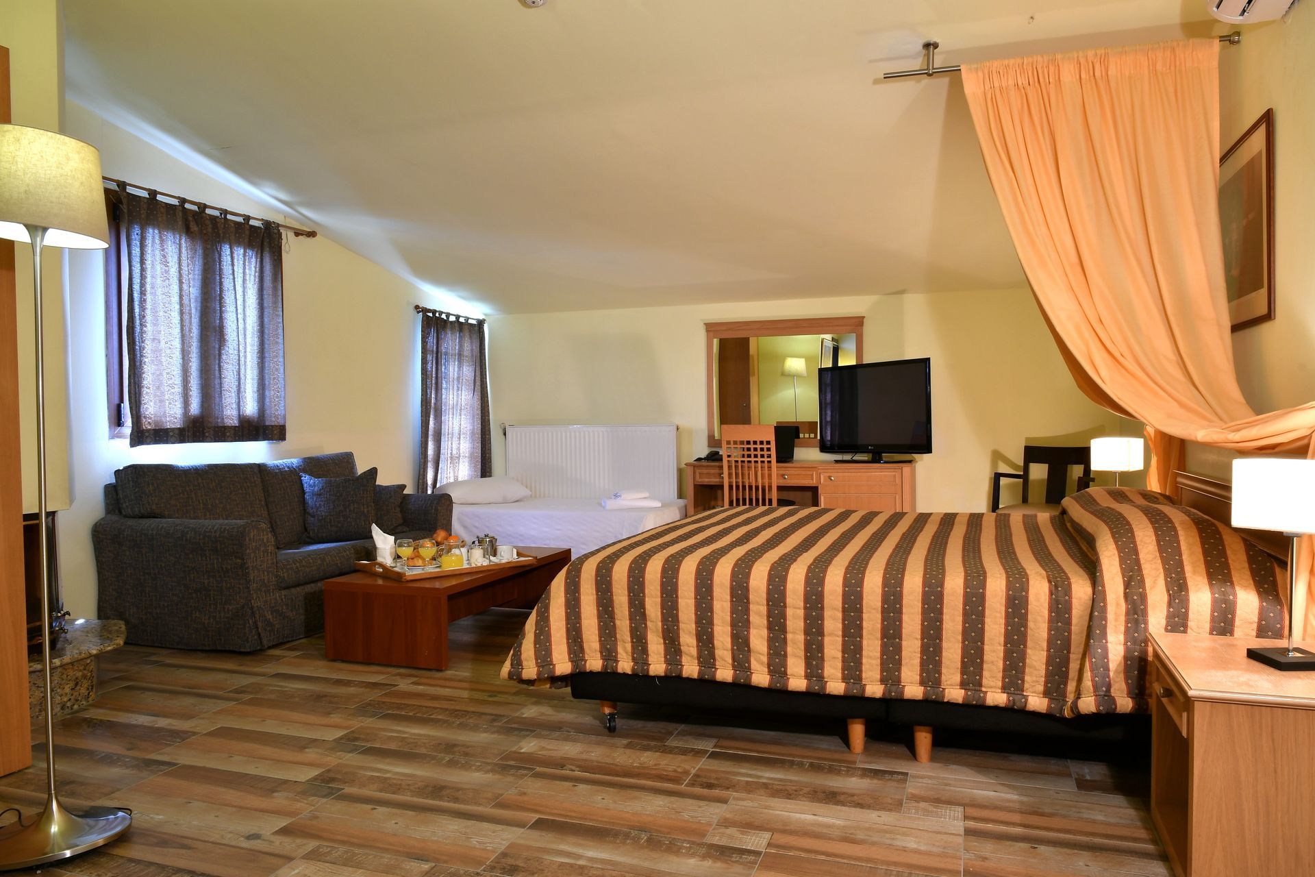 A hotel room with a canopy bed and a couch