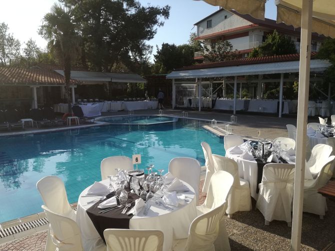 Tables and chairs are set up in front of a swimming pool