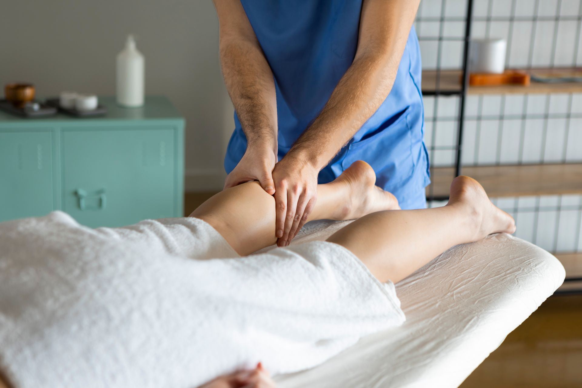 Hands inserting acupuncture needles into a person's lower back.