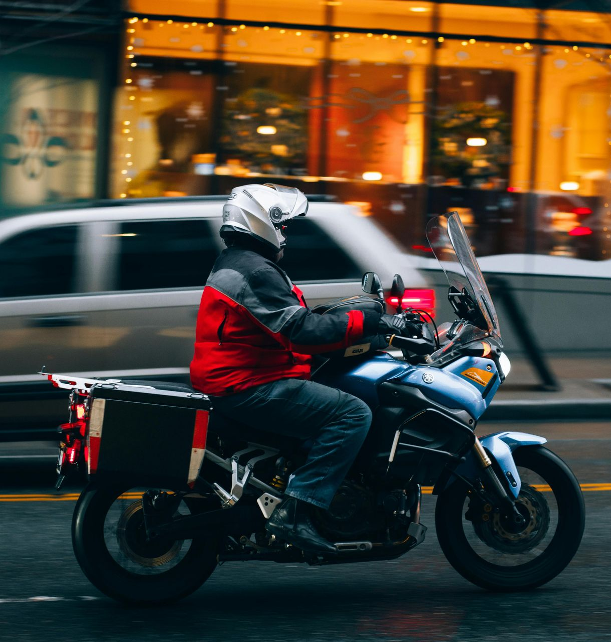 A man is riding a motorcycle down a street.