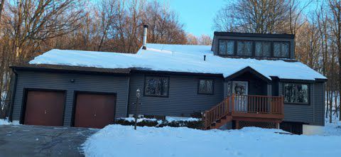 A large house with a lot of snow on the roof.