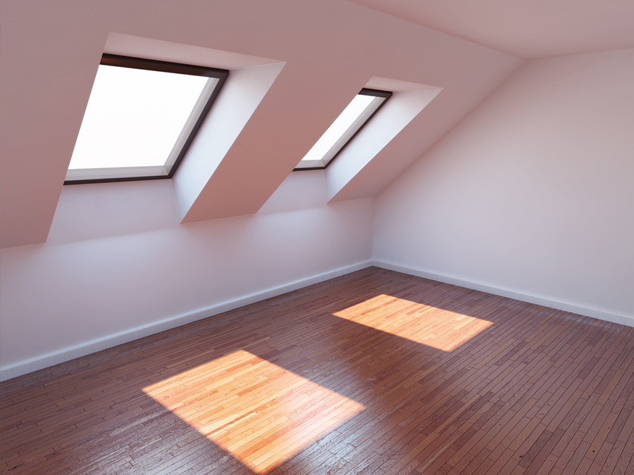 An empty room with two skylights on the ceiling