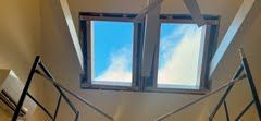 A skylight in the ceiling of a building with stairs leading up to it.
