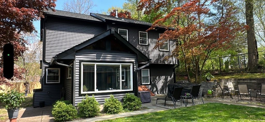 A large house with a lot of windows and a patio in front of it.