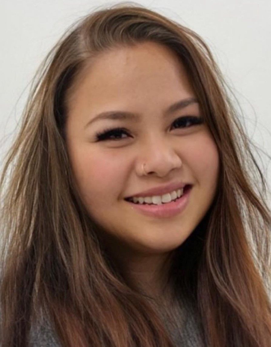 A woman with long brown hair is smiling for the camera