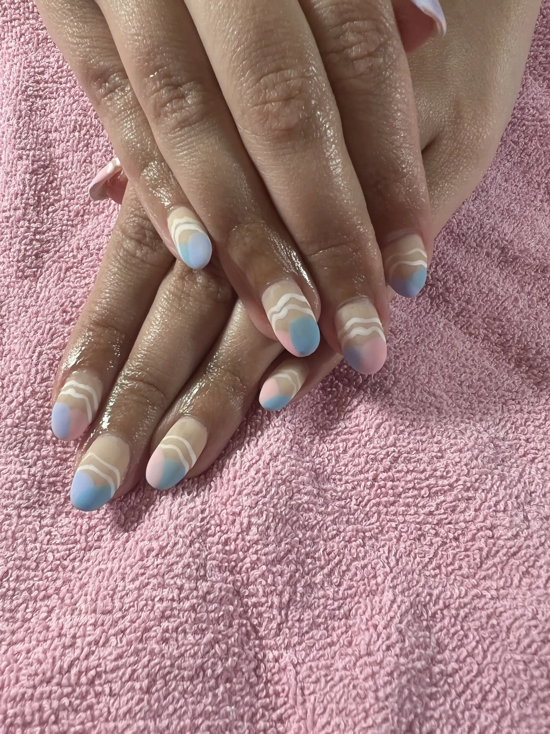 A close up of a person 's nails on a pink towel.