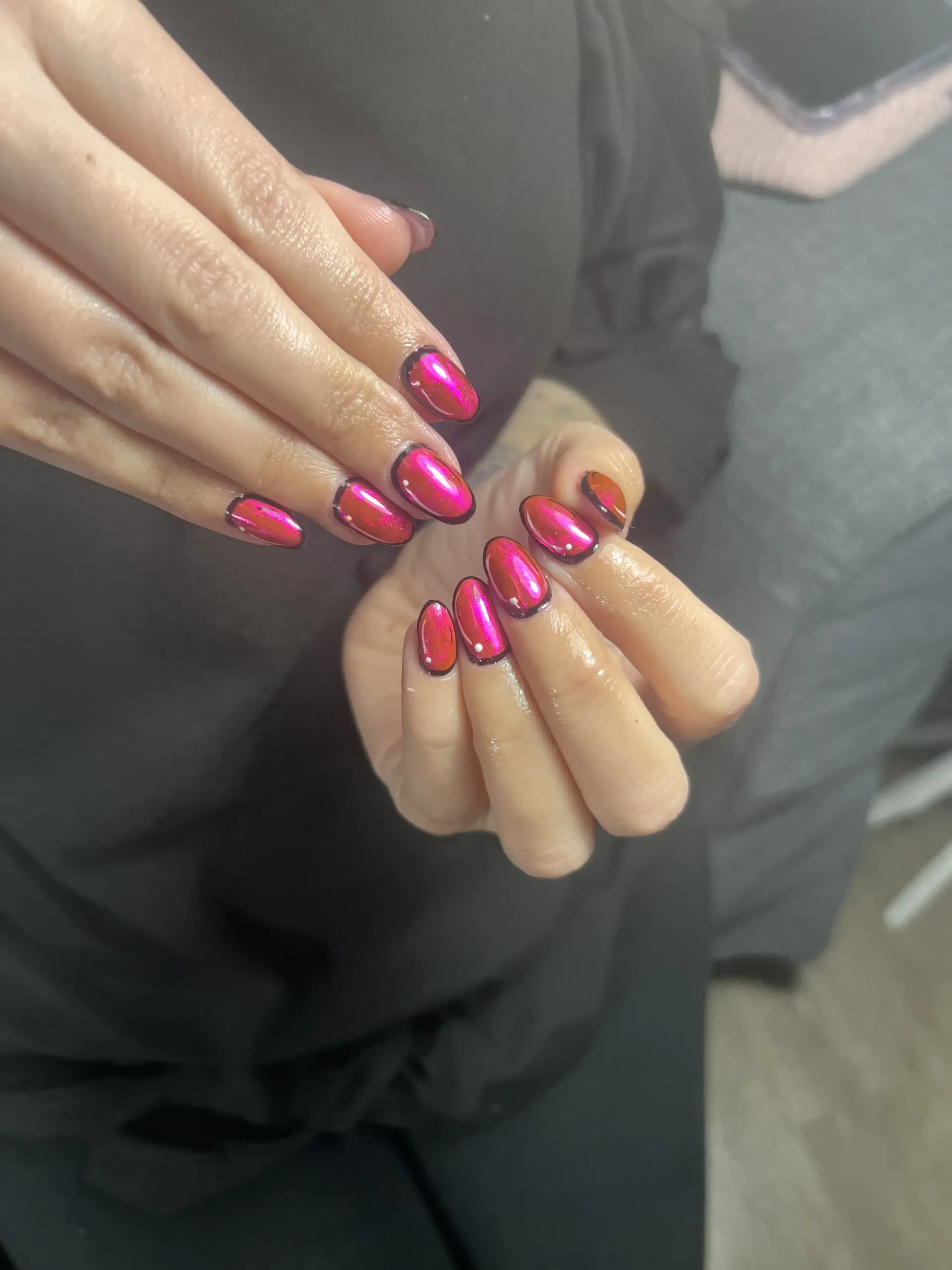 A close up of a woman 's hands with red nails.