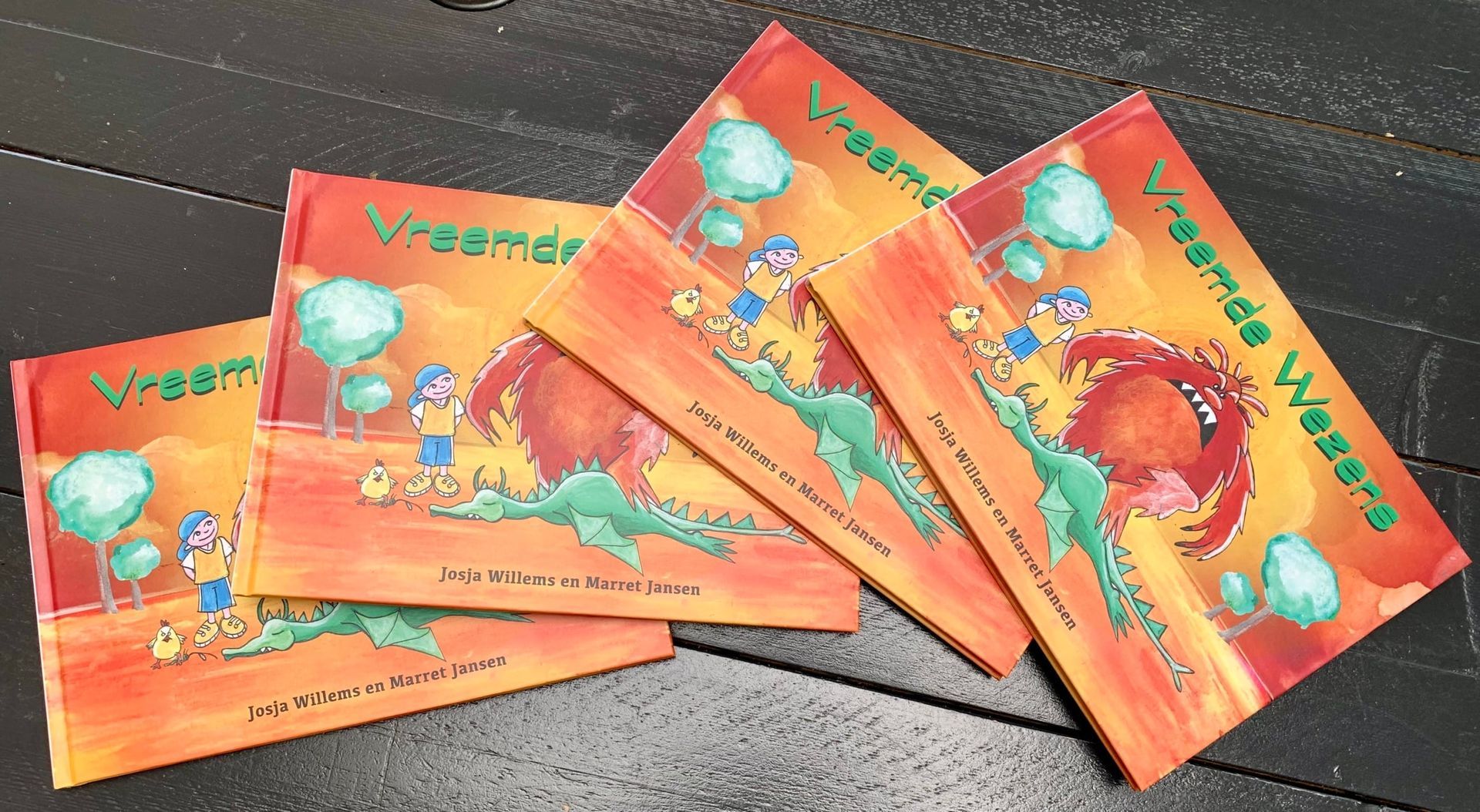 Vijf oranje foliepakketjes met kleurrijke cartoonafbeeldingen en Chinese tekst, uitgespreid op een donkere tafel.