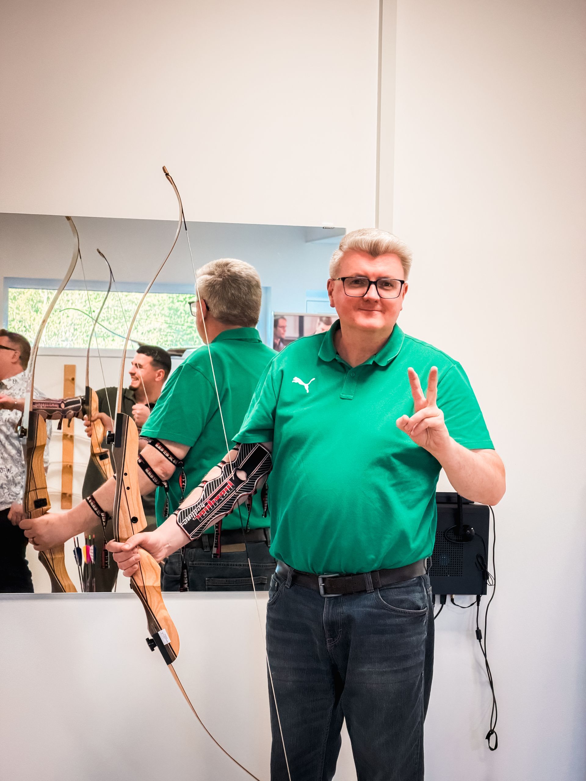 Drei Männer im Haus, einer in grauer Jacke, die Arme verschränkt, zwei andere mit Brille. Einer zeigt mit dem Finger.