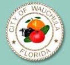 City of Wauchula, Florida seal featuring an orange, a red tomato, and a mechanical device.