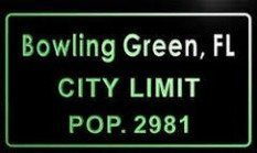 Sign indicating the city limit of Bowling Green, Florida. Features text in green on a black background, including the city name,