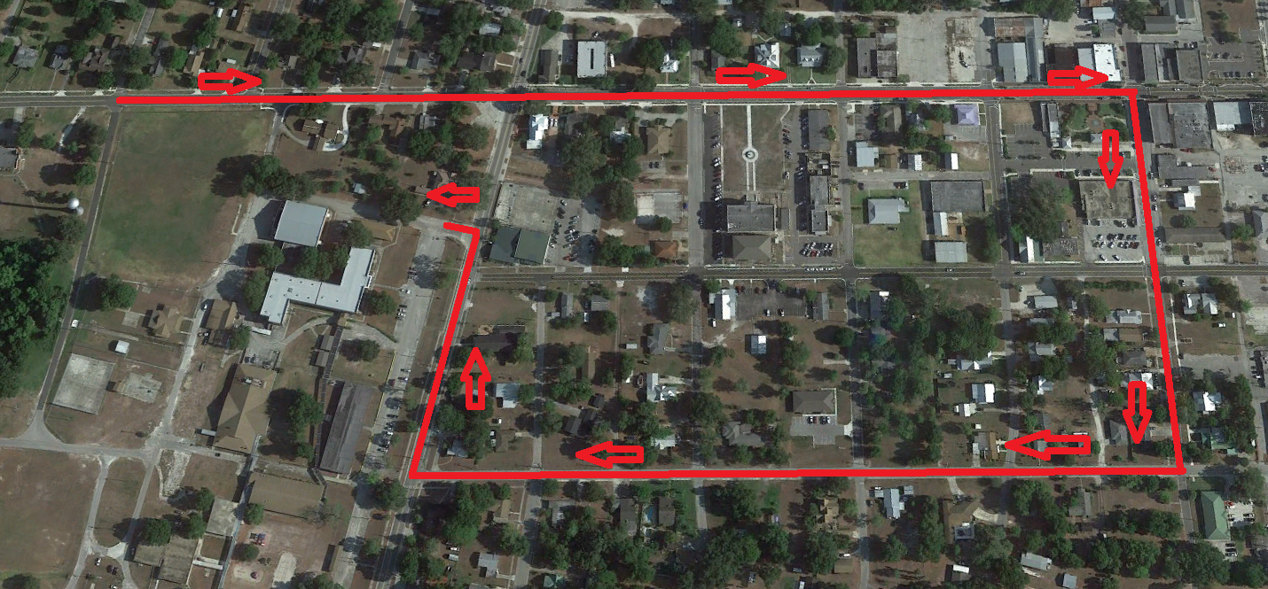 Aerial view of a town outlined in red, with red markers at various points along the outline.