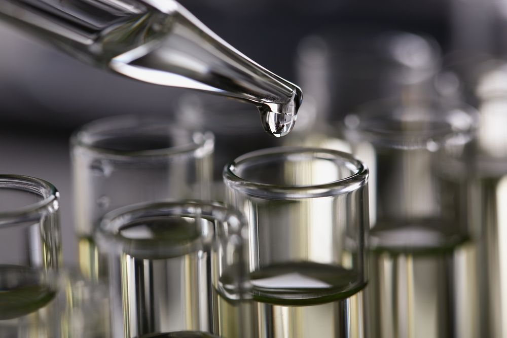Laboratory pipette dispensing liquid into small glass vials