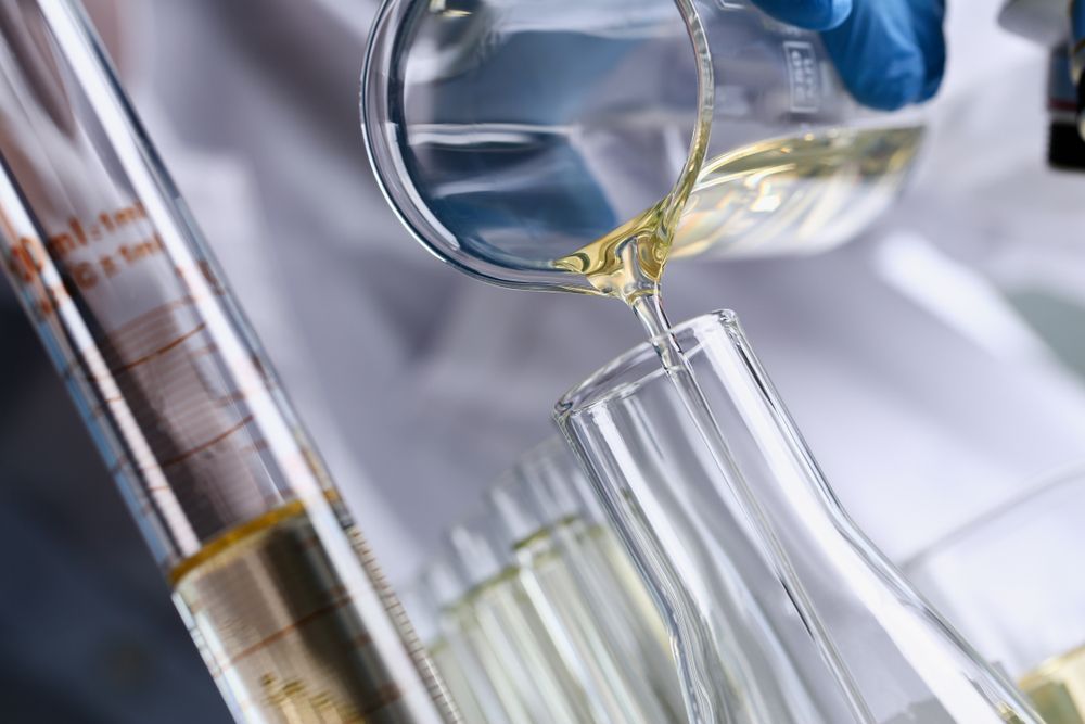 a person is pouring solvent into a beaker .