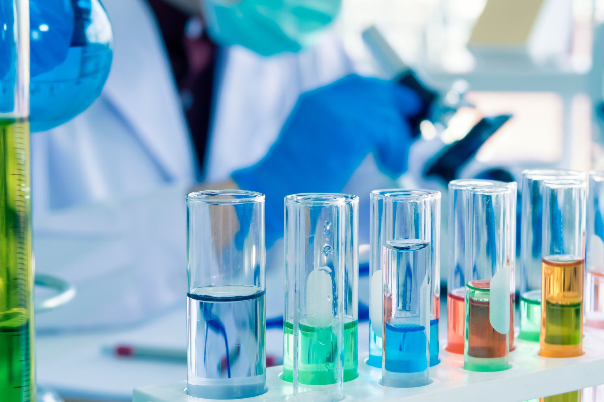 a scientist is working in a laboratory with test tubes filled with different colored liquids practicing green chemistry