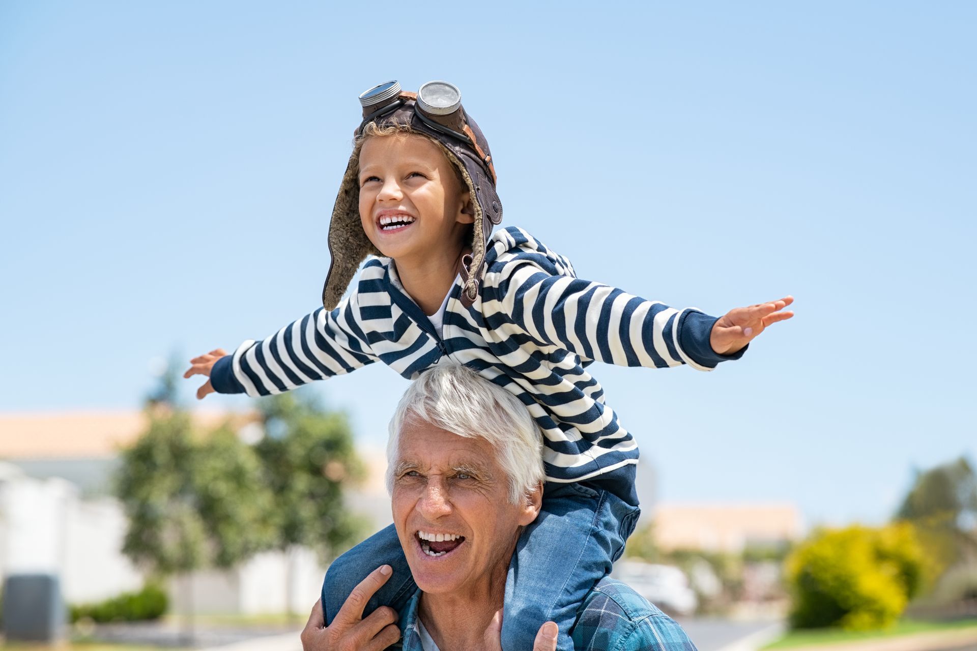 The grandson sits on the shoulders of the grandfather 'playing airplanes' after learning the effects of 2-Butanone