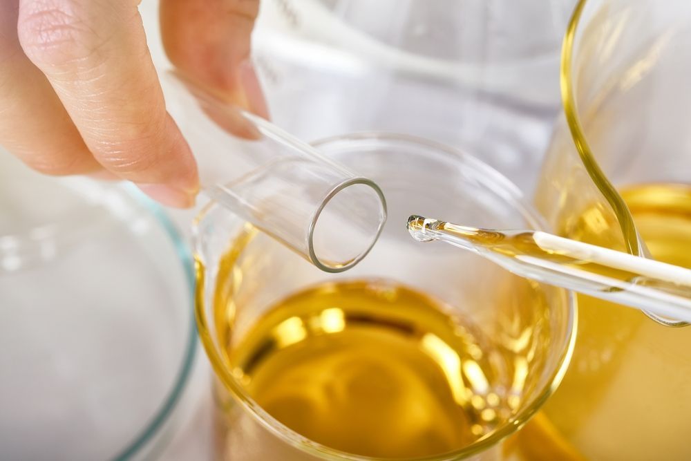 a person is pouring solvent into a glass with a pipette .