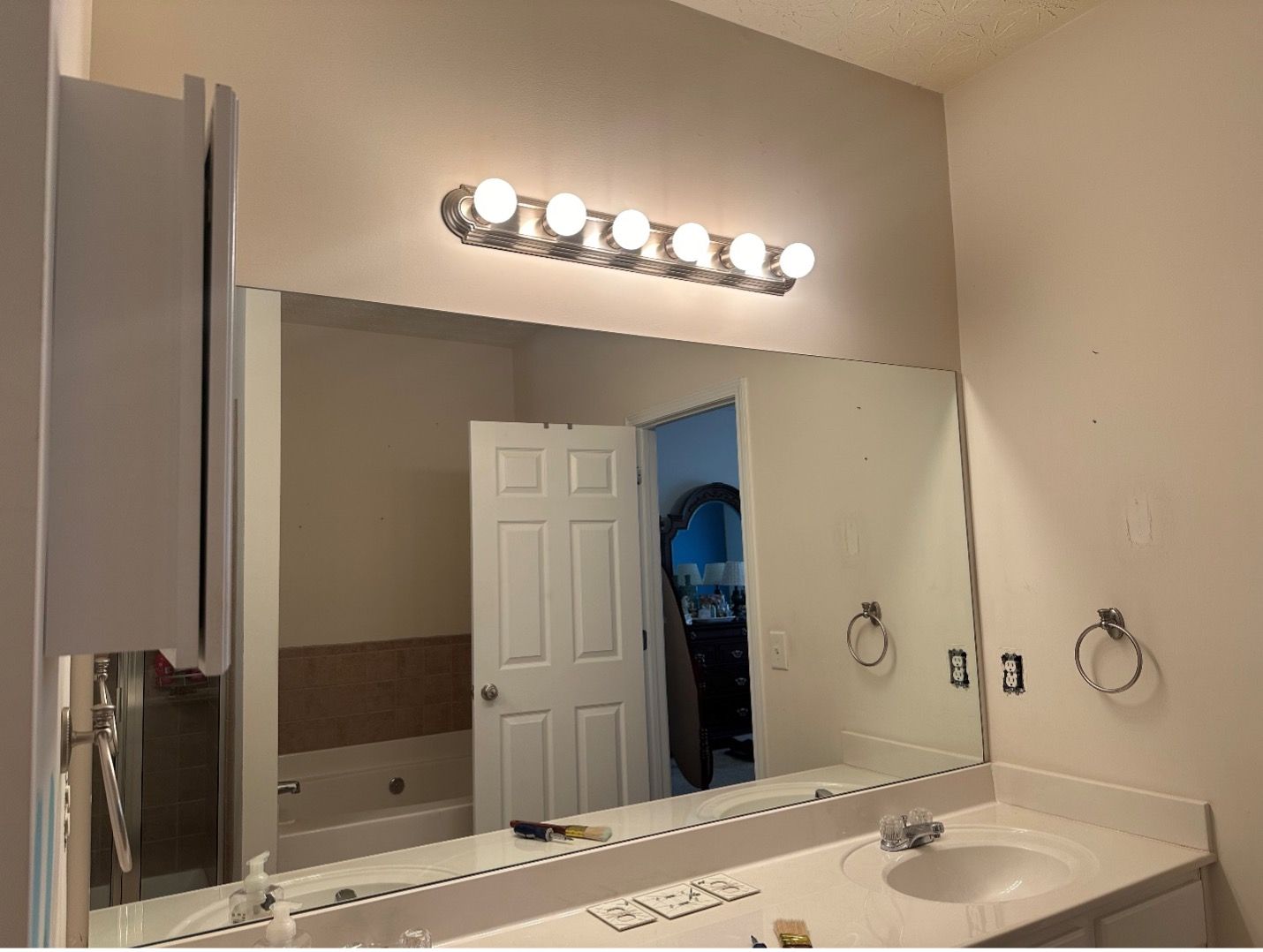 A bathroom with a large mirror and a sink.