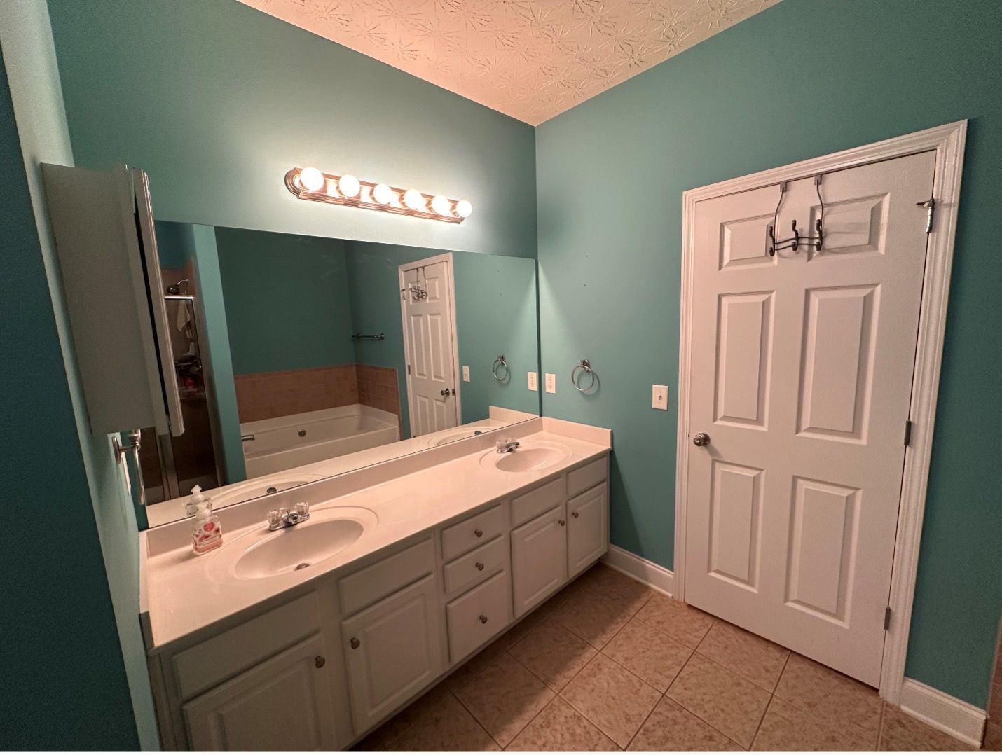 A bathroom with two sinks and a large mirror