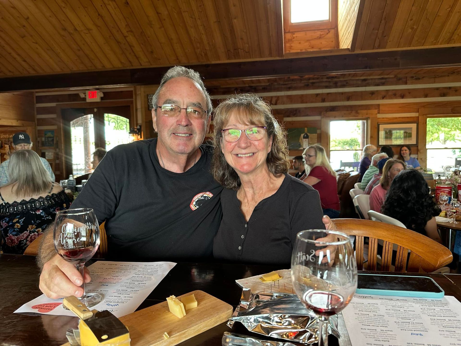 A man and a woman are sitting at a table with a glass of wine.