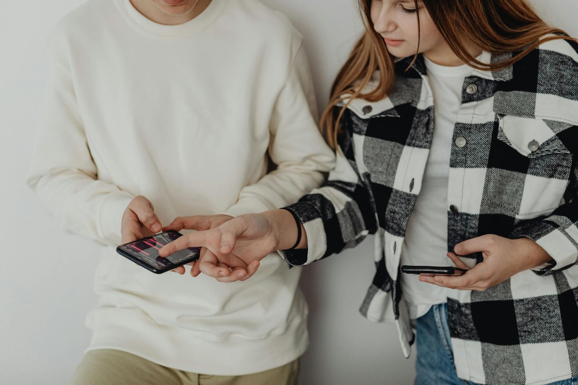 A man and a woman are looking at their phones.