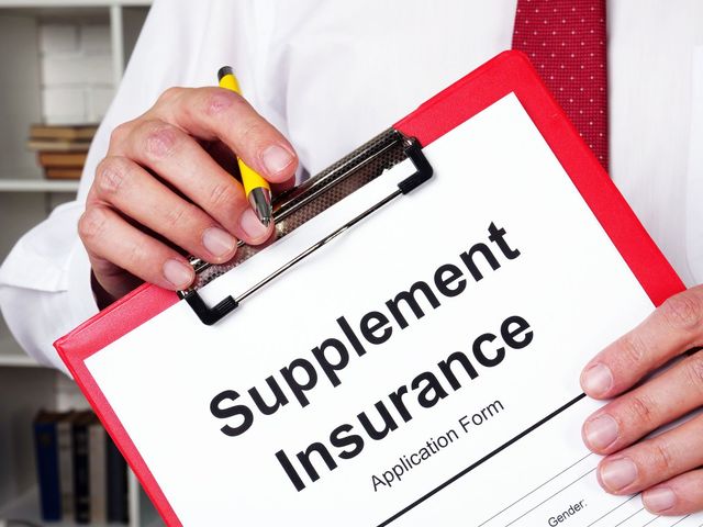 Hands holding a clipboard with a “Supplement Insurance” application form and red border