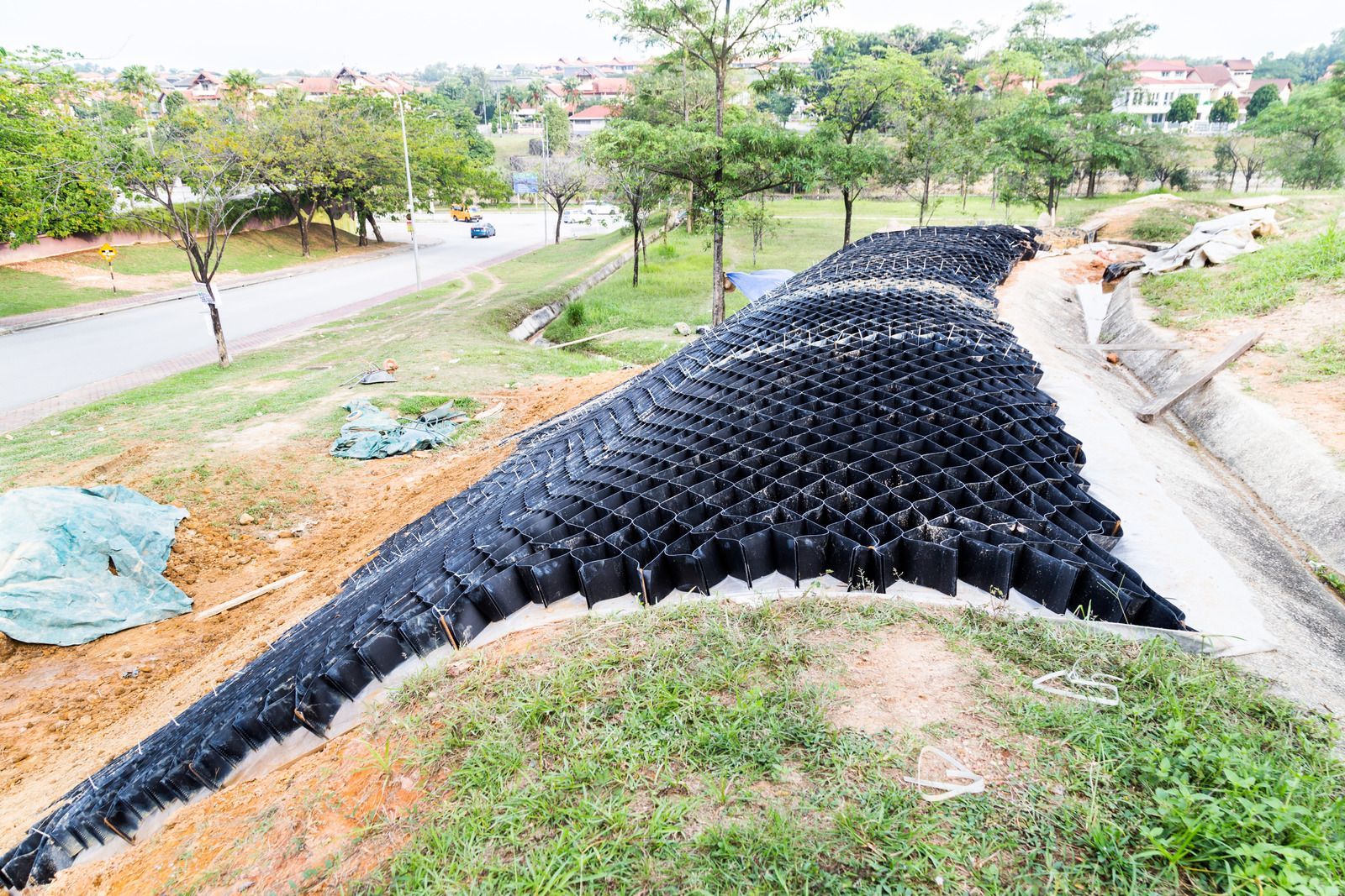 Black geocell structure stabilizing a hillside.