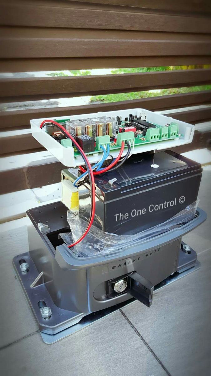 An open autogate motor system showing the internal circuit board, wiring, and a backup battery