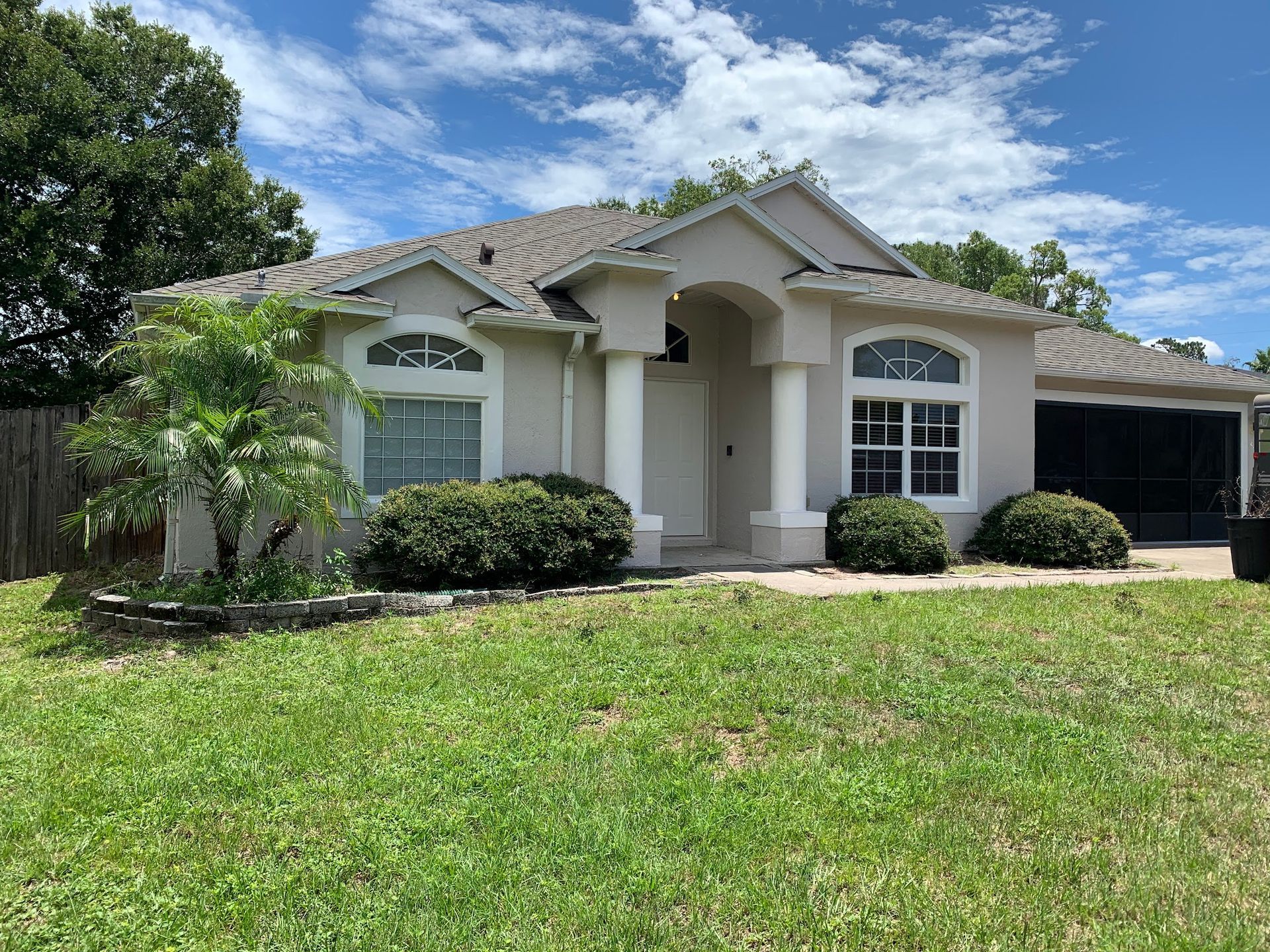 A house with a lush green lawn in front of it.