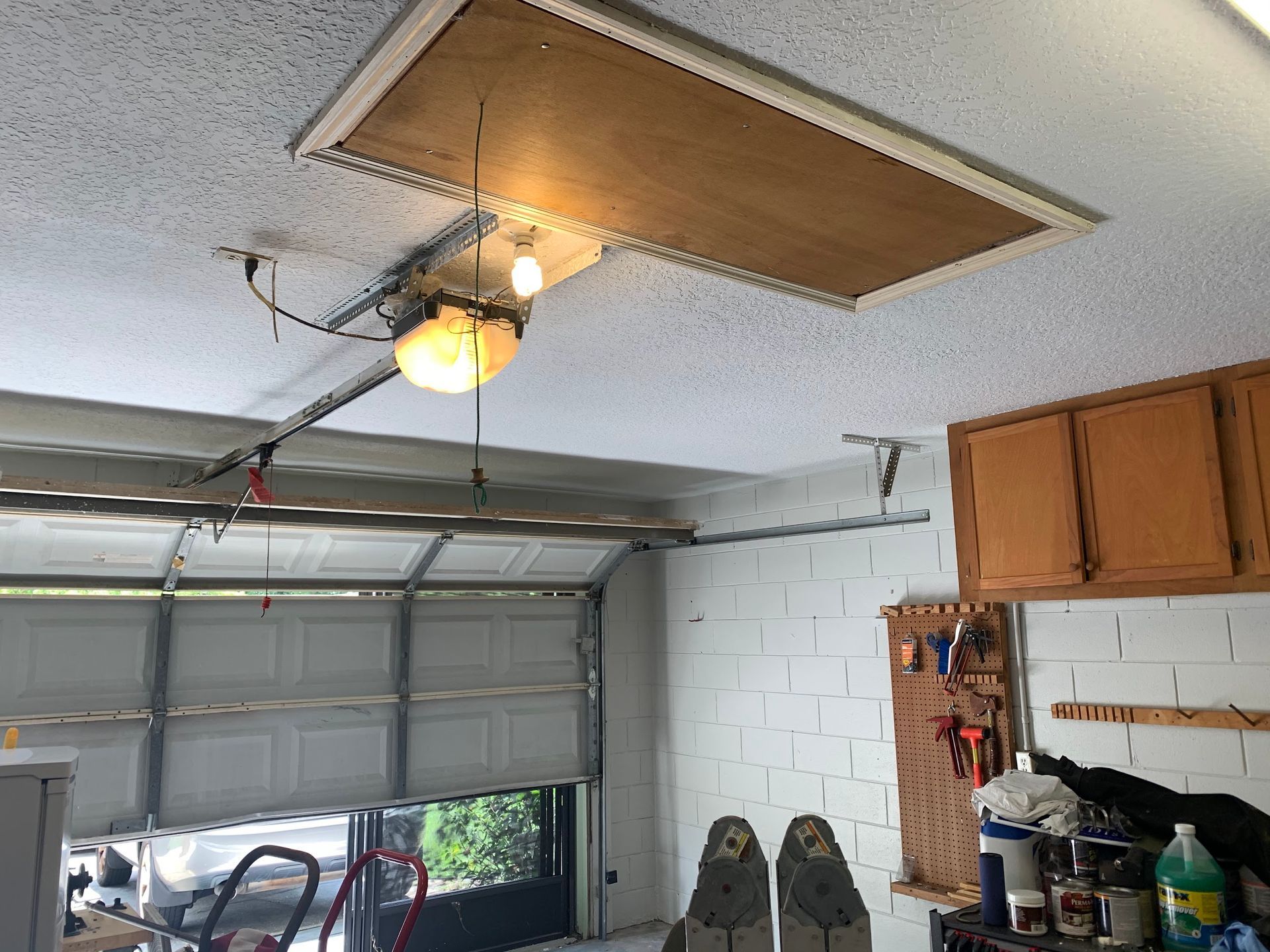A garage with a door open and a light on the ceiling.