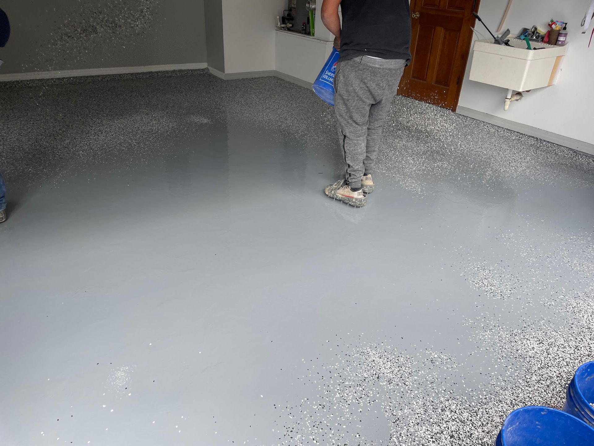 A man is standing on a concrete floor in a garage.
