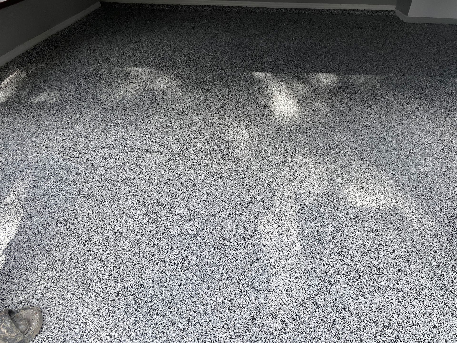 A black and white photo of a carpeted floor in a room.