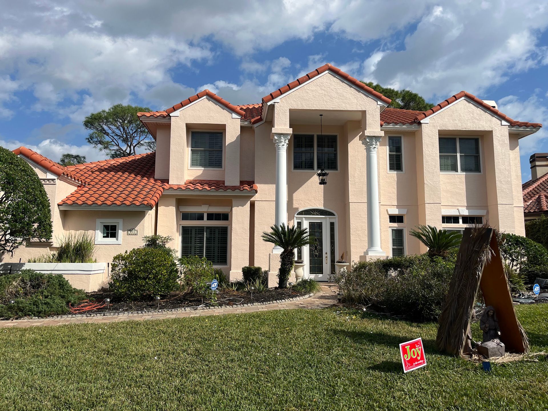 A large house with a for sale sign in front of it.