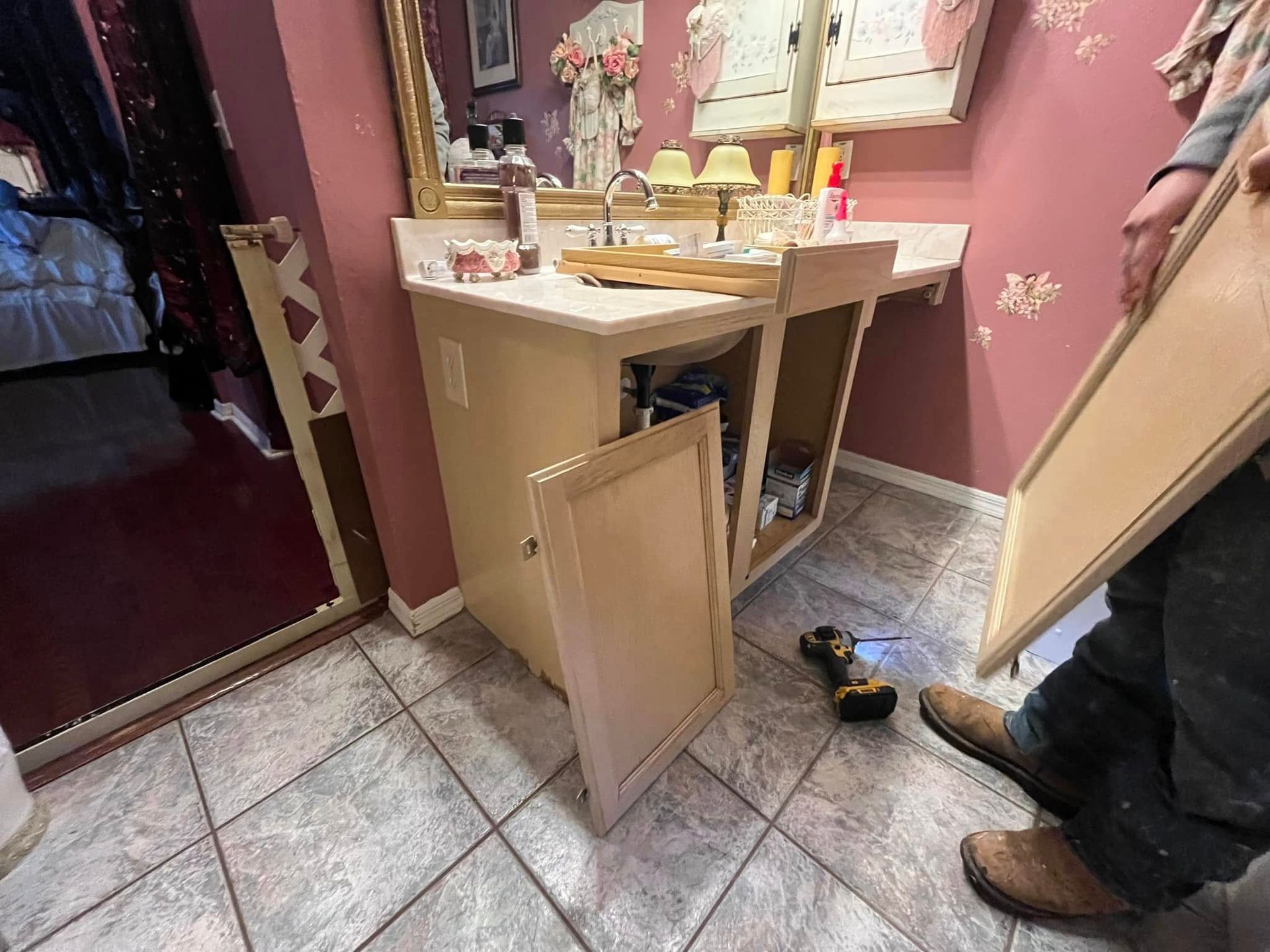 A man is holding a piece of wood in front of a bathroom sink.